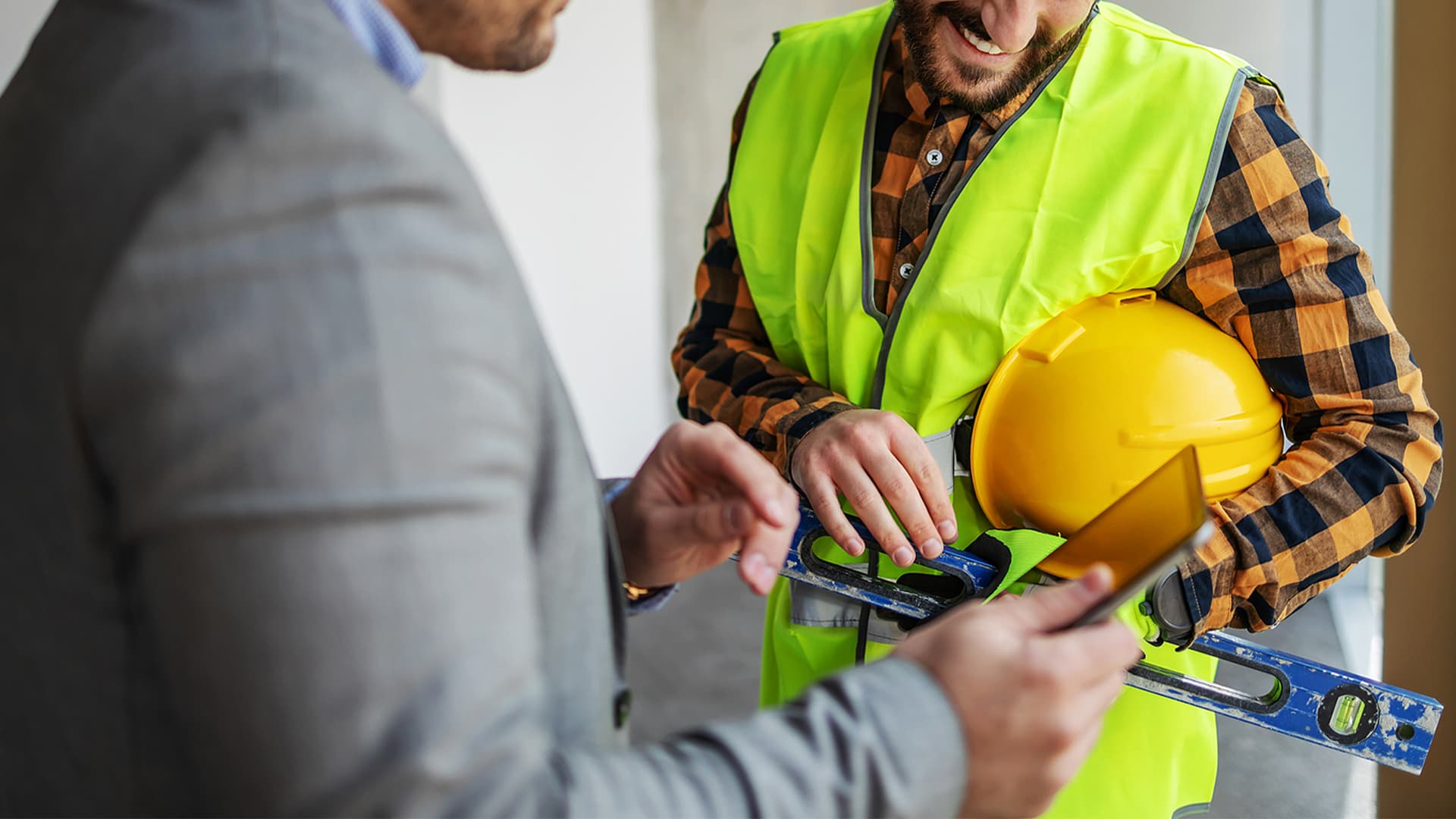 A commercial builder and client look at a tablet together