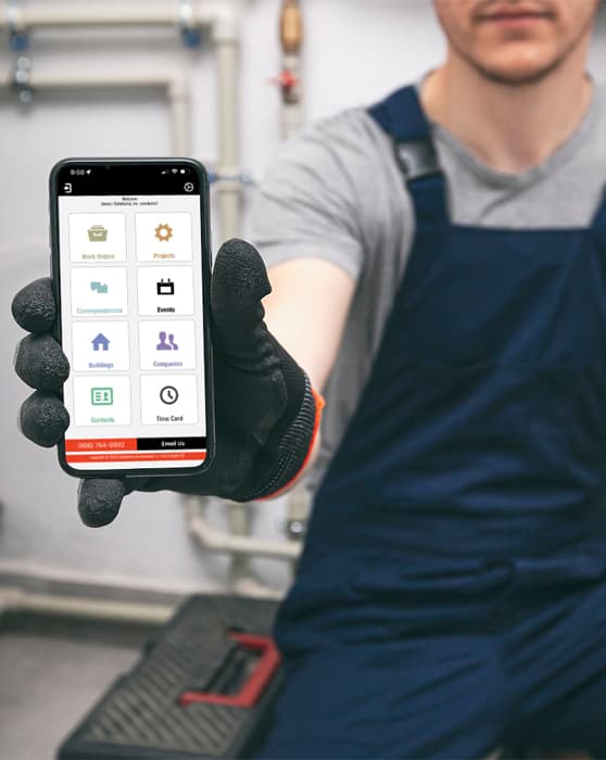 A commercial plumber holding a cell phone displaying the Dataforma mobile app