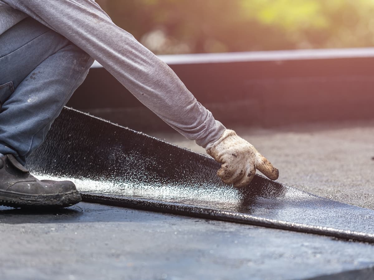 Commercial roofing installation on flat roof by man