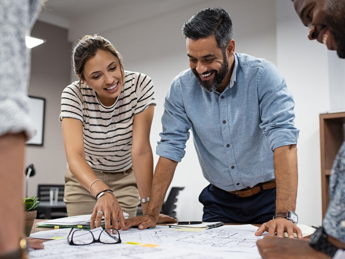 A man and a woman look over paperwork, planning a construction project