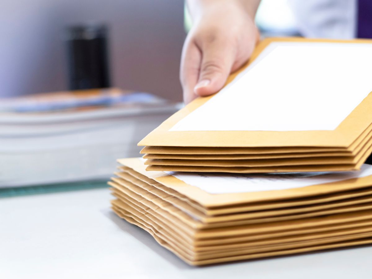 A person placing down documents on top of another stack of documents.