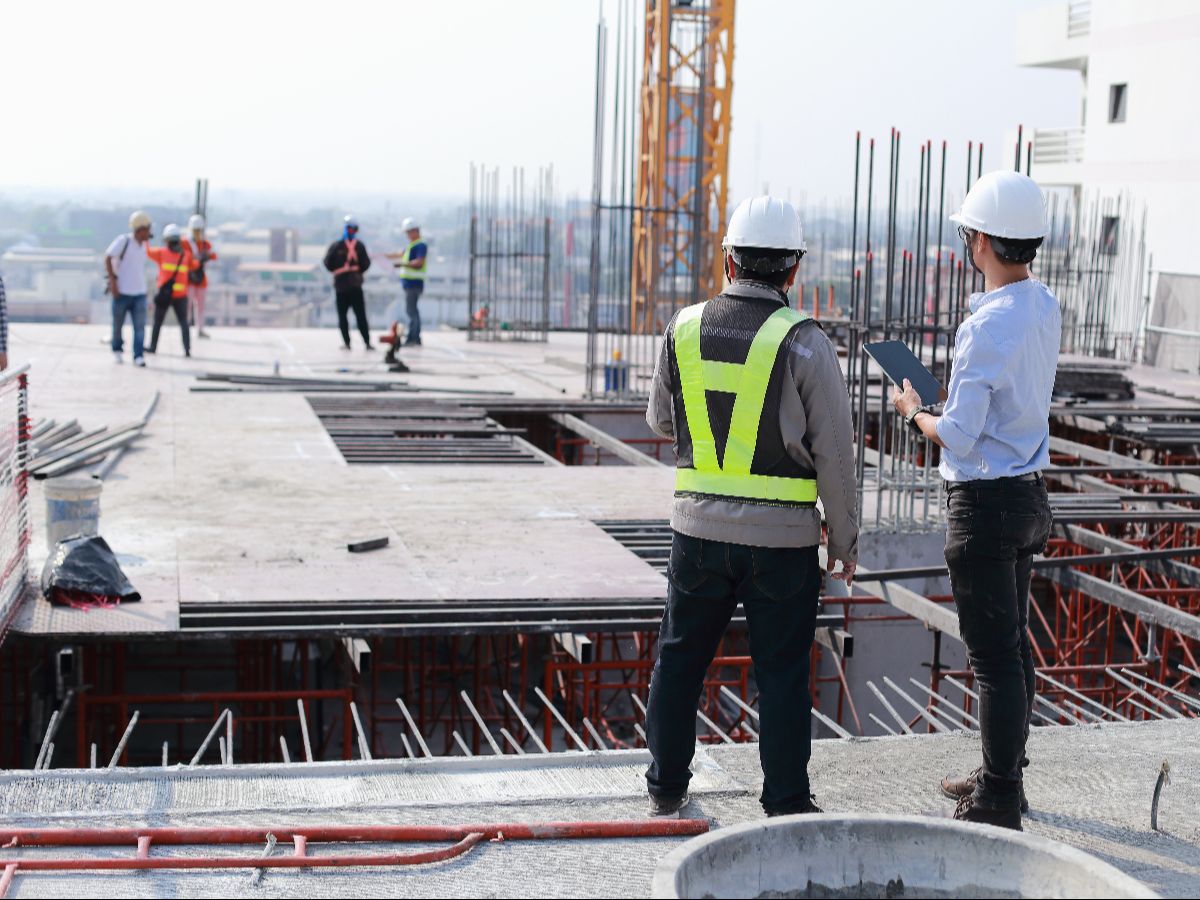 A group of construction workers standing at a construction site.
