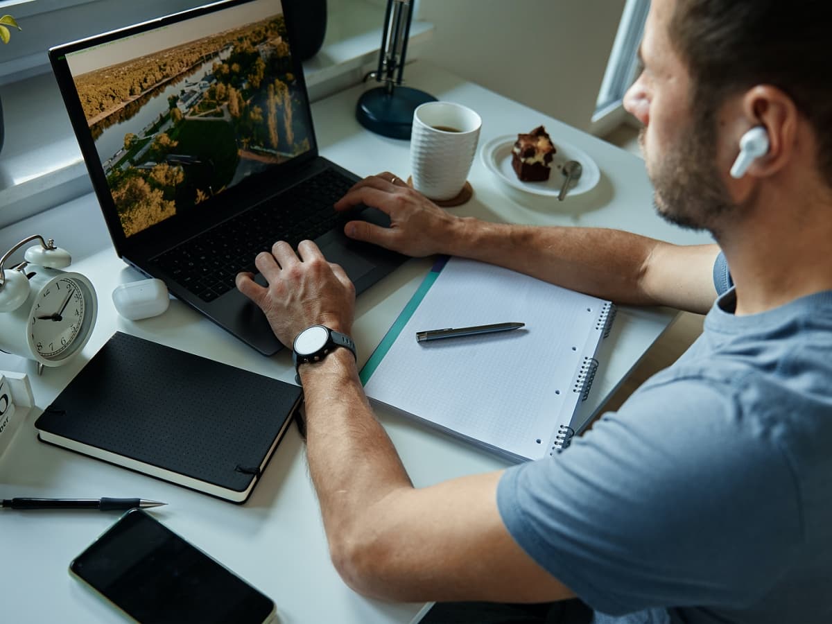 Businessman multitasking with laptop and headphones