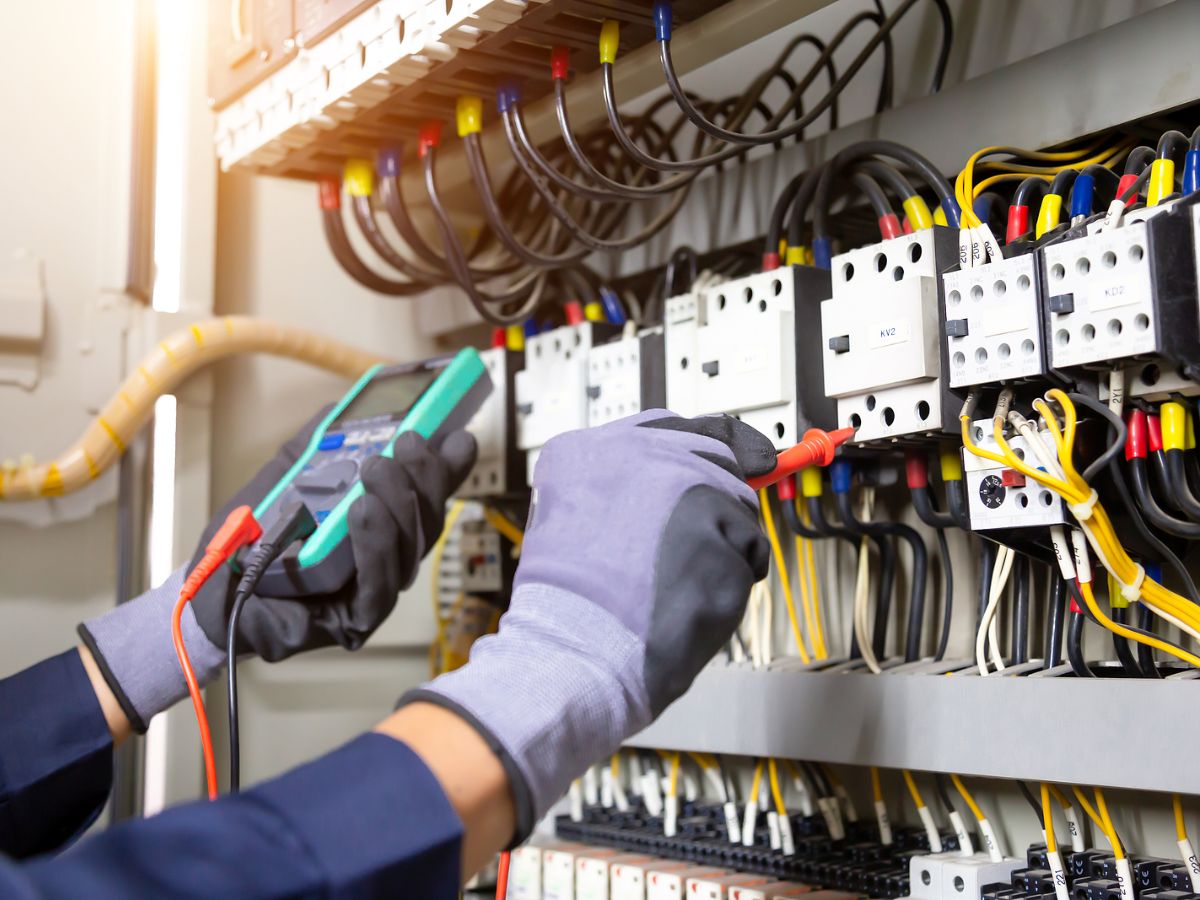 An electrical contractor who uses integrated software solutions to plan workflows works on an electrical system.